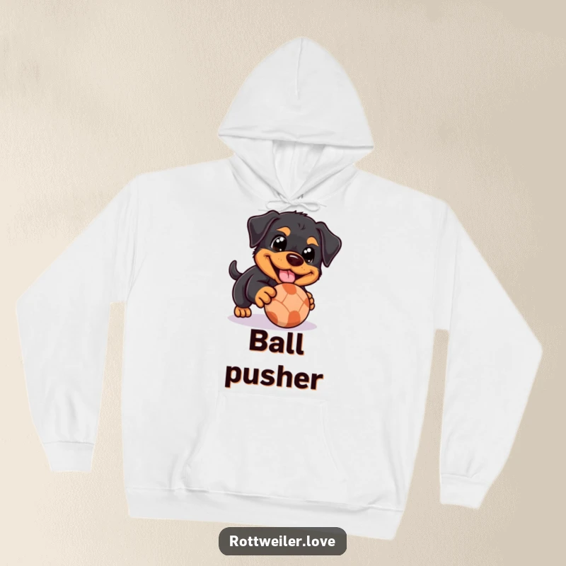 Funny Rottweiler hoodie displaying a dog with happy eyes playfully nudging a rolling ball, offering cozy comfort and sweet charm.